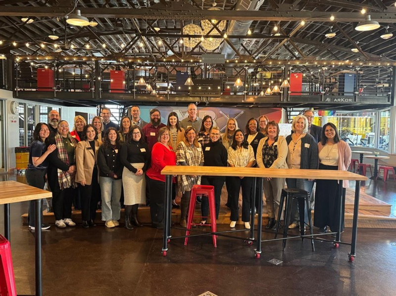 Group photo of about 30 people standing and smiling