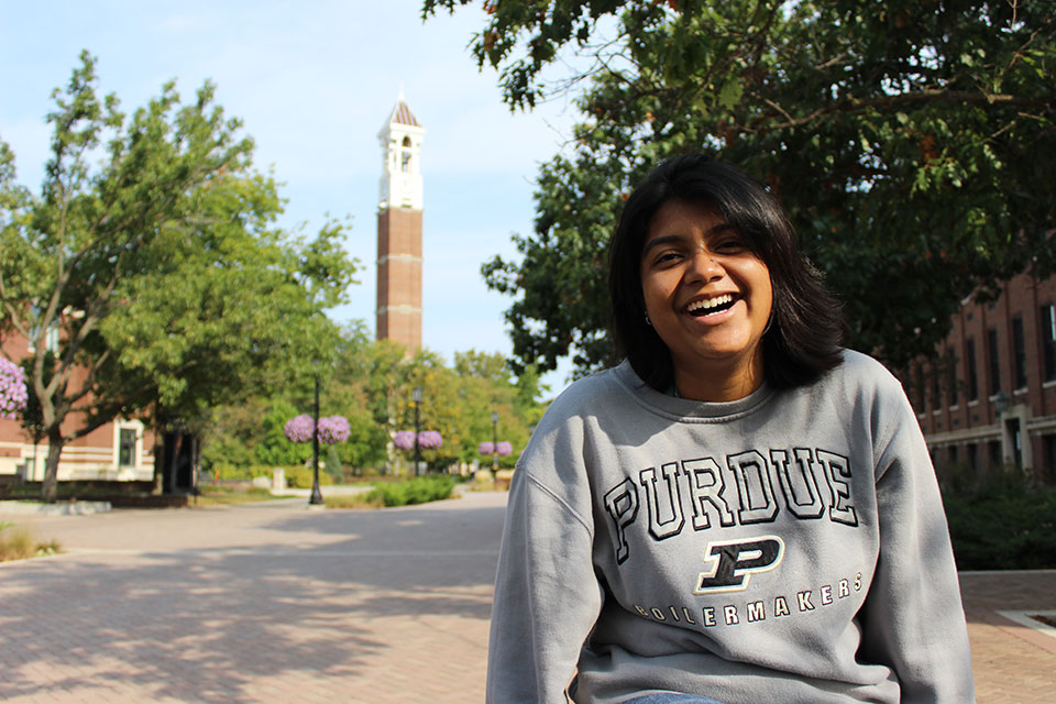 student with clock town in the background