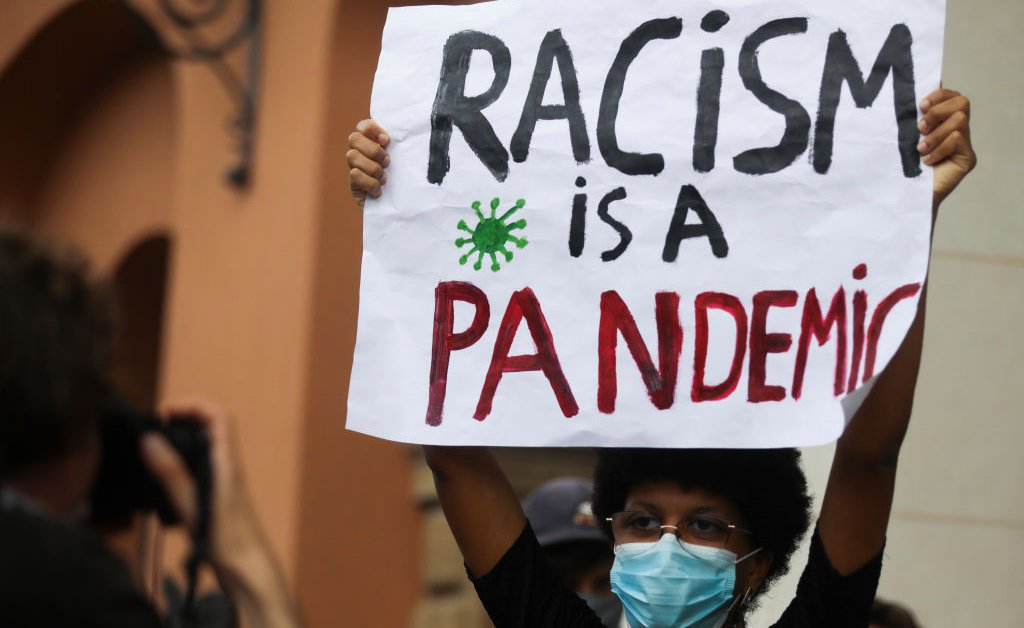 Sign that says racism is a pandemic
