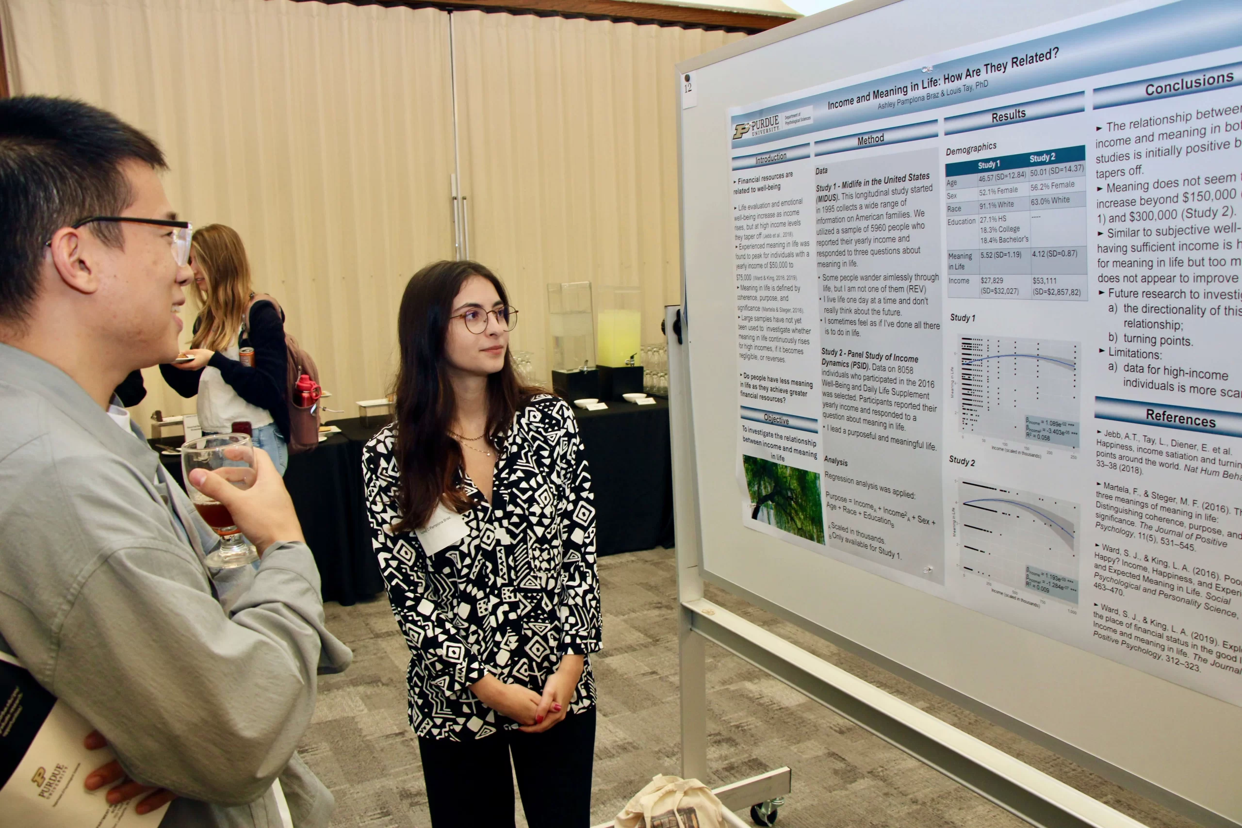 Ashley demonstrating to another person about the content on her poster.