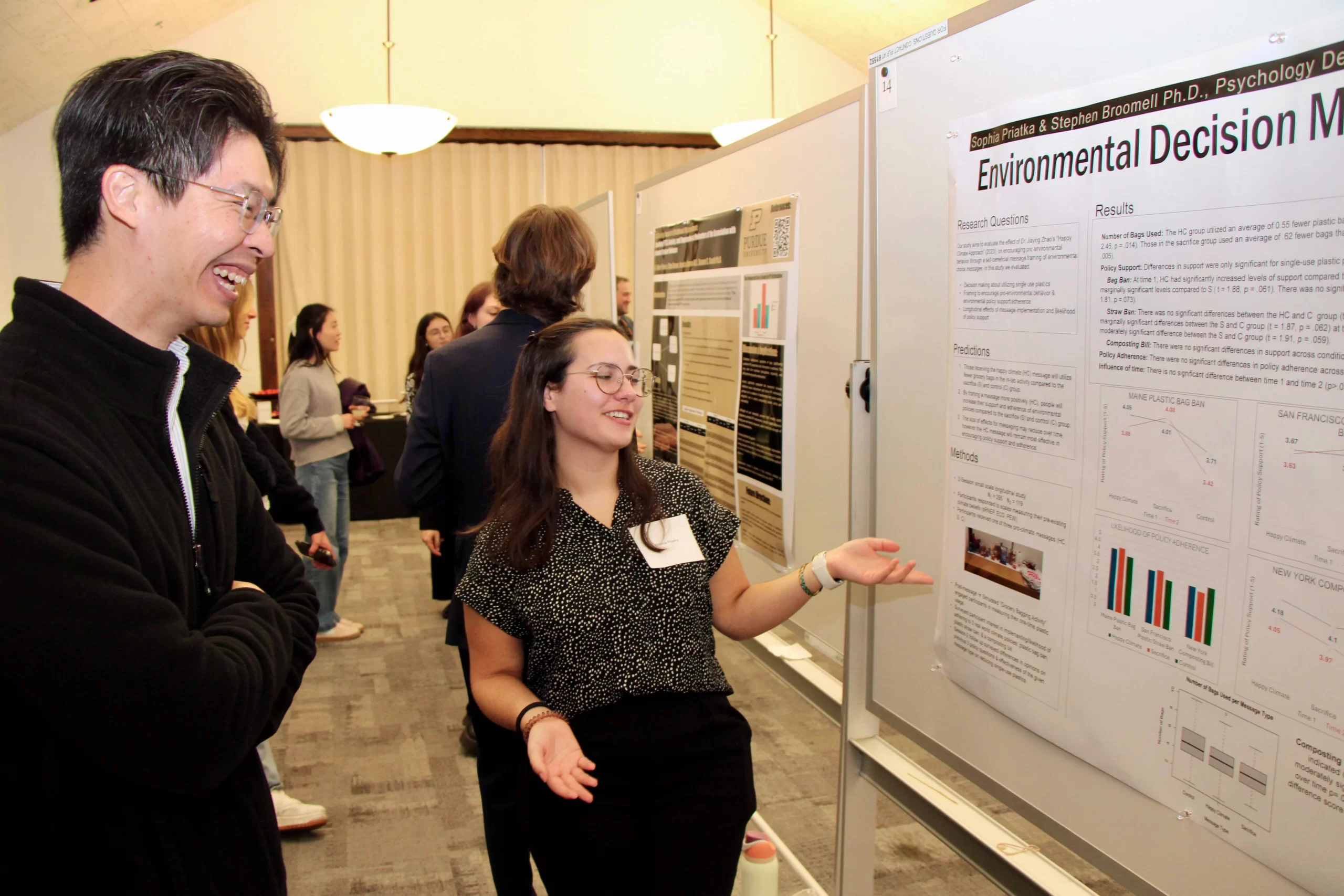 Sophia conversing with another person about her poster.